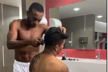 Pedro Pablo Perlaza corta el cabello de un compañero antes de la sesión de fotos para un auspiciante.