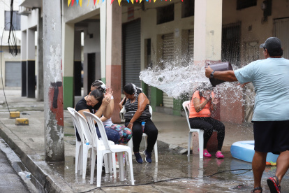 Una persona juega con agua potable, por el carnavaL, en el centro de Guayaquil.