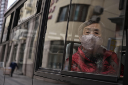Una mujer que llevaba una máscara facial viaja en un autobús en Shangai el 2 de marzo de 2020. El número global de muertos por la nueva epidemia de coronavirus superó los 3.000