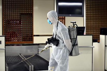 Personas desinfectan áreas del Aeropuerto Internacional de Baghdad (Irak) como medida de precaución.