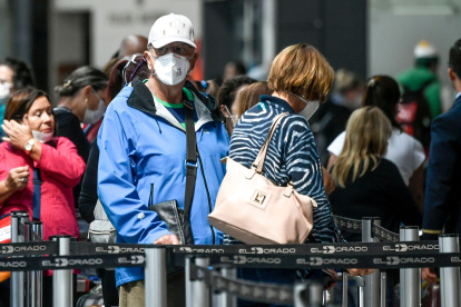 Passengers use face masks as a precautionary measure against the spread of the new coronavirus, COVID-19, at El Dorado international airport in Bogota on March 17, 2020.  Quarantine, schools, shops and borders closed, gatherings banned, are the main measures being taken in many countries across the world to fight the spread of the novel coronavirus. / AFP / Juan BARRETO

 COLOMBIA-HEALTH-VIRUS
