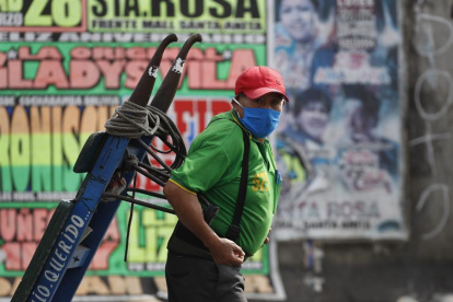Un hombre con tapabocas trabaja en el Mercado Mayorista de Frutas de Lima (Perú). Casi sin recursos y sin otras opciones, Perú comenzará formalmente a reabrir su cuarentena.