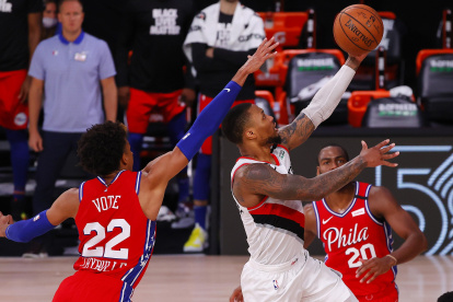 Damian Lillard (c), de los Portland Trail Blazers, penetra en la defensa de Philadelphia.