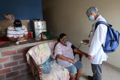 El médico Jonathan Pasquel le toma la presión a una ciudadana en el sector Los Vergeles.
