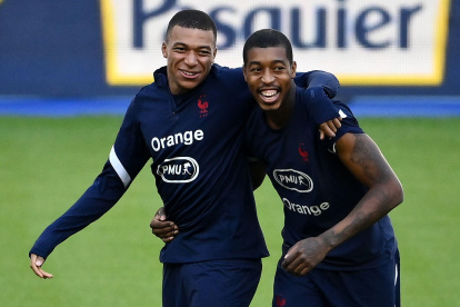 Kylian Mbappé (i) compartiendo junto a Presnel Kimpembe (d) durante la práctica de este lunes, antes de conocer su positivo.