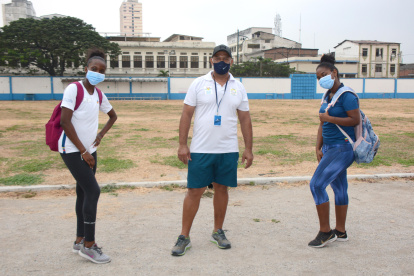 Equipo. Kiara Rodríguez, de salto largo (i); el entrenador Bernardo Valdés y Seneida Rodríguez, de impulsión de bala y lanzamiento de disco, luego de uno de los entrenamientos.