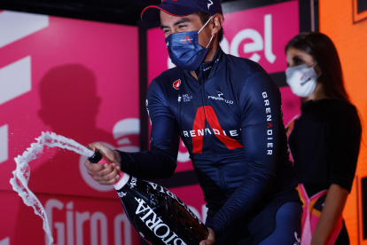 El ciclista ecuatoriano en la cúspide celebrando con el champán de los ganadores de etapa del Giro de Italia 2020.