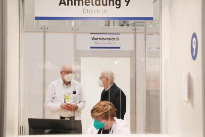 El alcalde de Hamburgo, Peter Tschentscher (d) habla con el director médico del centro de vacunación de la ciudad, Dirk Heinrich (i), sobre el inicio de la campaña de inmuinización.