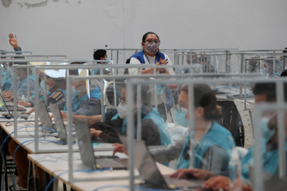 Personas trabajan en la delegación Provincial de Pichincha del Consejo Nacional Electoral ecuatoriano, donde se reciben las actas con los resultados de las elecciones presidenciales 2021, en Quito.