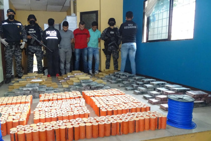 Los detenidos junto a drogas y explosivos incautados por la Policía.