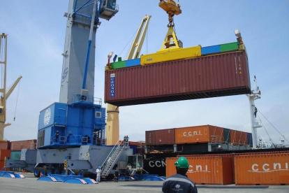 GRÚA MOVILIZA UN CONTAINER O CONTENEDOR EN EL MUELLE DEL PUERTO.