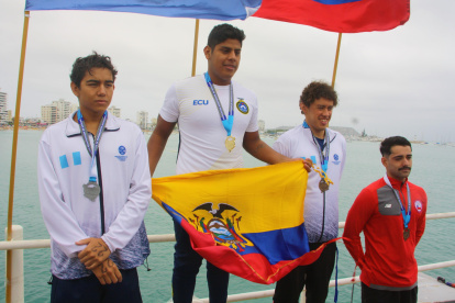 David Farinango (c), nadador ecuatoriano, muestra la bandera tricolor en el podio tras ganar la medalla de oro.
