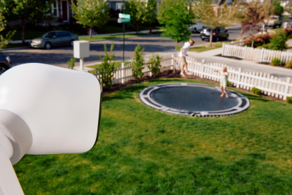 Observación. Dos niños juegan en el área frontal de una casa, mientras son supervigilados por una cámara.