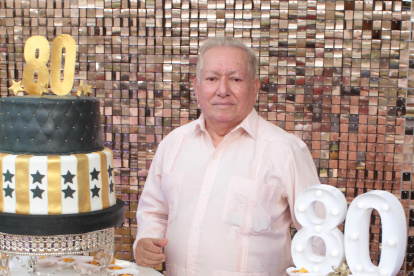 El cumpleañero feliz junto a la torta.