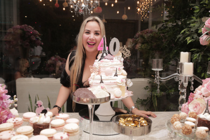 María del Mar posa junto a la mesa de dulces y la preciosa torta de cumpleaños.