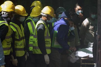 Miembros de la policía de Nepal inspeccionan los cuerpos de las víctimas del avión ATR72 de Yeti Airlines después de llevarlos al Hospital Universitario de Katmandú, este 17 de enero.