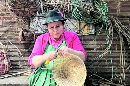 Arte. Una indígena confecciona una cesta artesanal.