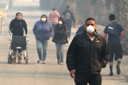 En la imagen de archivo, varios residentes usan máscaras para evitar inhalar el humo producto del incendio Thomas en Ventura, California, (Estados Unidos).