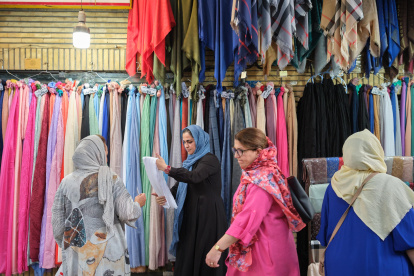 Una mujer compra un velo en una tienda del norte de Teherán, Irán. La venta de hiyabs se ha disparado en Irán desde el regreso a las calles de la Policíade la moralpara reimponer el uso de la prenda islámica.