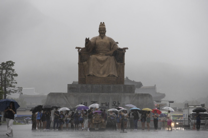 La gente camina con paraguas en medio de una fuerte lluvia en la plaza Gwanghwamun en Seúl, Corea del Sur, el 17 de julio de 2024. (Corea del Sur, Seúl)