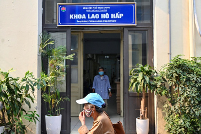 Una mujer caminando frente a la entrada del departamento de tuberculosis respiratoria del Hospital Nacional del Pulmón en Hanoi.