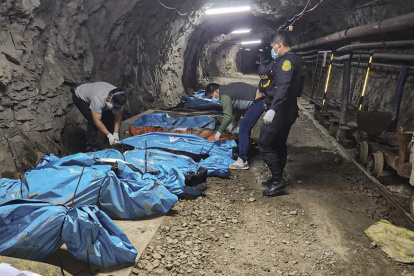 Foto difundida por la Policía de La Libertad el 4 de mayo de 2025 que muestra a agentes de policía junto a los cuerpos de 13 trabajadores encontrados muertos dentro de una mina de oro en Pataz.