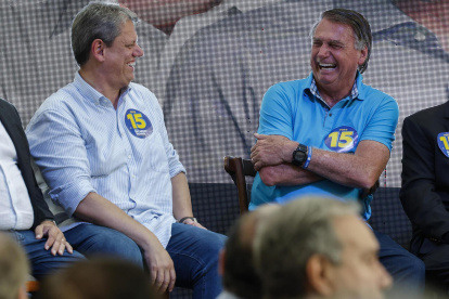 El expresidente ultraderechista brasileño Jair Bolsonaro (2019-2022) (d) ríe junto al gobernador del estado de Sao Paulo, Tarcísio de Freitas (i), durante un acto de campaña.