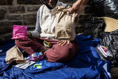 Genese Hubbard, asesora de recuperación en el Centro de Empleo Nuestro Pan Diario, reparte suministros y Narcan a una mujer sin hogar en Baltimore, Maryland.