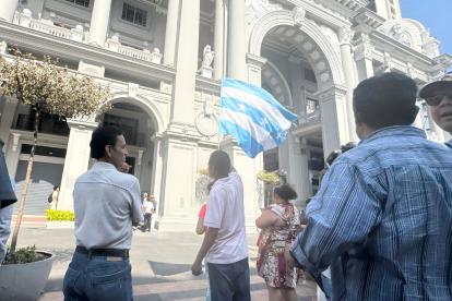 Ciudadanos permanecen en los exteriores del Municipio de Guayaquil durante el allanamiento ejecutado por la Fiscalía, en el marco de una investigación por presunta falsificación de documentos.