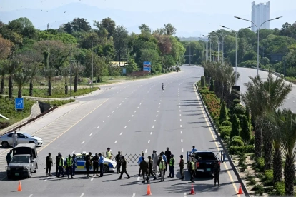 Personal de seguridad monta guardia en un puesto de control en una carretera temporalmente cerrada cerca del Hotel Serena, en la Zona Roja de Islamabad, el 20 de abril de 2026, antes de las esperadas conversaciones de paz entre Estados Unidos e Irán.