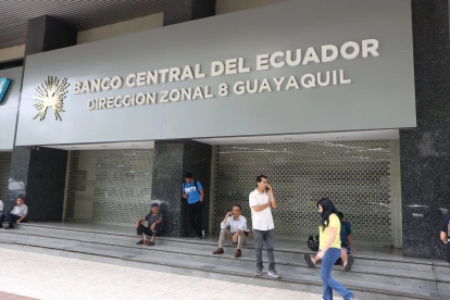 Personas caminan al pie del edificio del Banco Central de Ecuador, en Guayaquil.