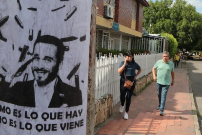 Personas caminan junto a un cartel alusivo al ultraderechista Abelardo de la Espriella.