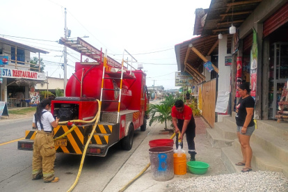 Personal del cuerpo de bomberos de Manglaralto colabora en el abastecimiento del líquido vital a los sectores donde el agua no llega