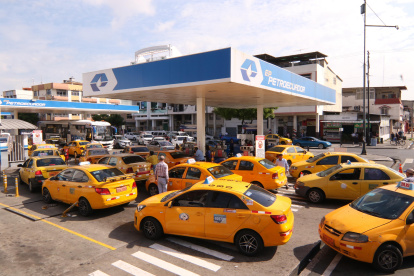 Un grupo de taxis hacen fila para poner combustible en una gasolinera en Guayaquil.