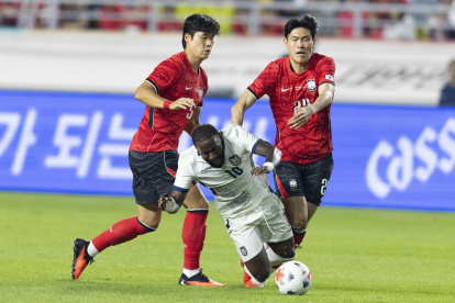 John Yeboah de Ecuador (C) cae ante la marca de Kim Bong-soo (d) y Kim Tae-hyeon de Corea del Sur el jueves pasado.