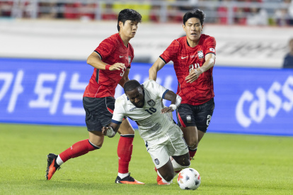 John Yeboah de Ecuador (C) cae ante la marca de Kim Bong-soo (d) y Kim Tae-hyeon de Corea del Sur el jueves pasado.