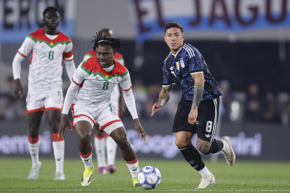 Enzo Fernández (d) de Argentina disputa el balón con Alain Kanté de Burkina Faso.