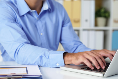 Cropped image of businessman working on laptop