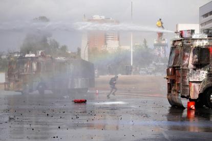 SANTIAGO. Fuerzas Especiales de Carabineros dispersan a un grupo de manifestantes este domingo en la céntrica plaza Italia de Santiago (Chile), rebautizada popularmente como ¿Plaza de la Dignidad.