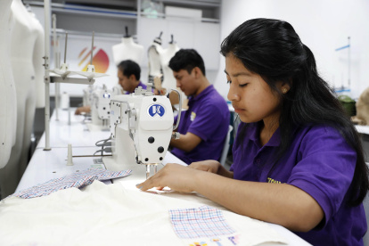 Una de las alumnas muestra la prenda creada para los niños quemados.