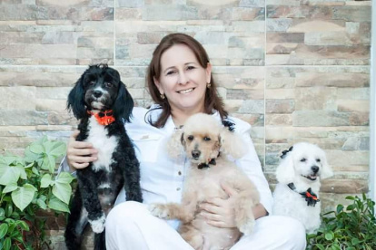 Prisca rodeada de varios perros rescatados.