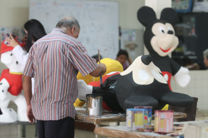 Usuarios del Instituto de Neurociencias, de la Junta de Beneficencia,construyen monigotes para la venta.