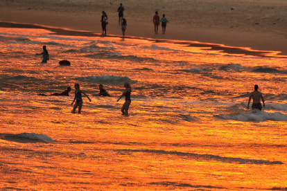 Bañistas disfrutan del atardecer en la playa de Bondi durante una ola de calor en Sydney