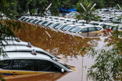 Los aldeanos verifican el estado de un puente destruido por una inundación.