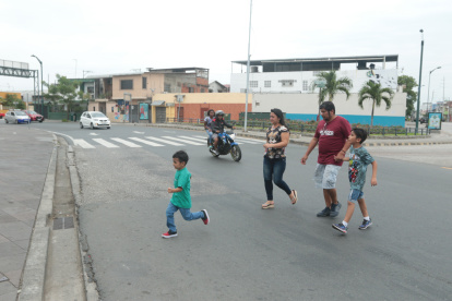 Las personas aceleran el paso para cruzar la calle.
