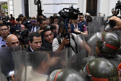 El líder de la oposición venezolana, Juan Guaido, lucha con los miembros de la Guardia Nacional a su llegada a la Asamblea Nacional.