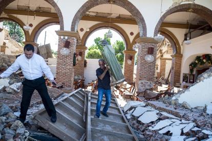 Un hombre lleva una estatua de San Judas de las ruinas de la iglesia Inmaculada Concepción, construida en 1841 y derrumbada después del terremoto.