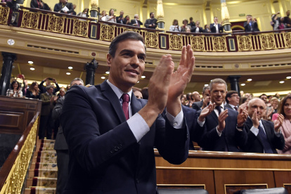 El socialista Pedro Sánchez aplaude después de ganar una votación parlamentaria en España.