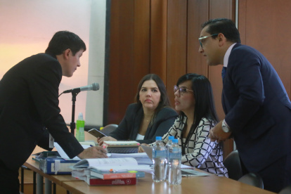 La investigada (centro) junto a su abogada en medio de la sala de audiencia.