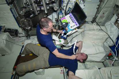 El astronauta Tom Marshburn realiza una exploración del cuello del astronauta Chris Hadfield en la ISS.